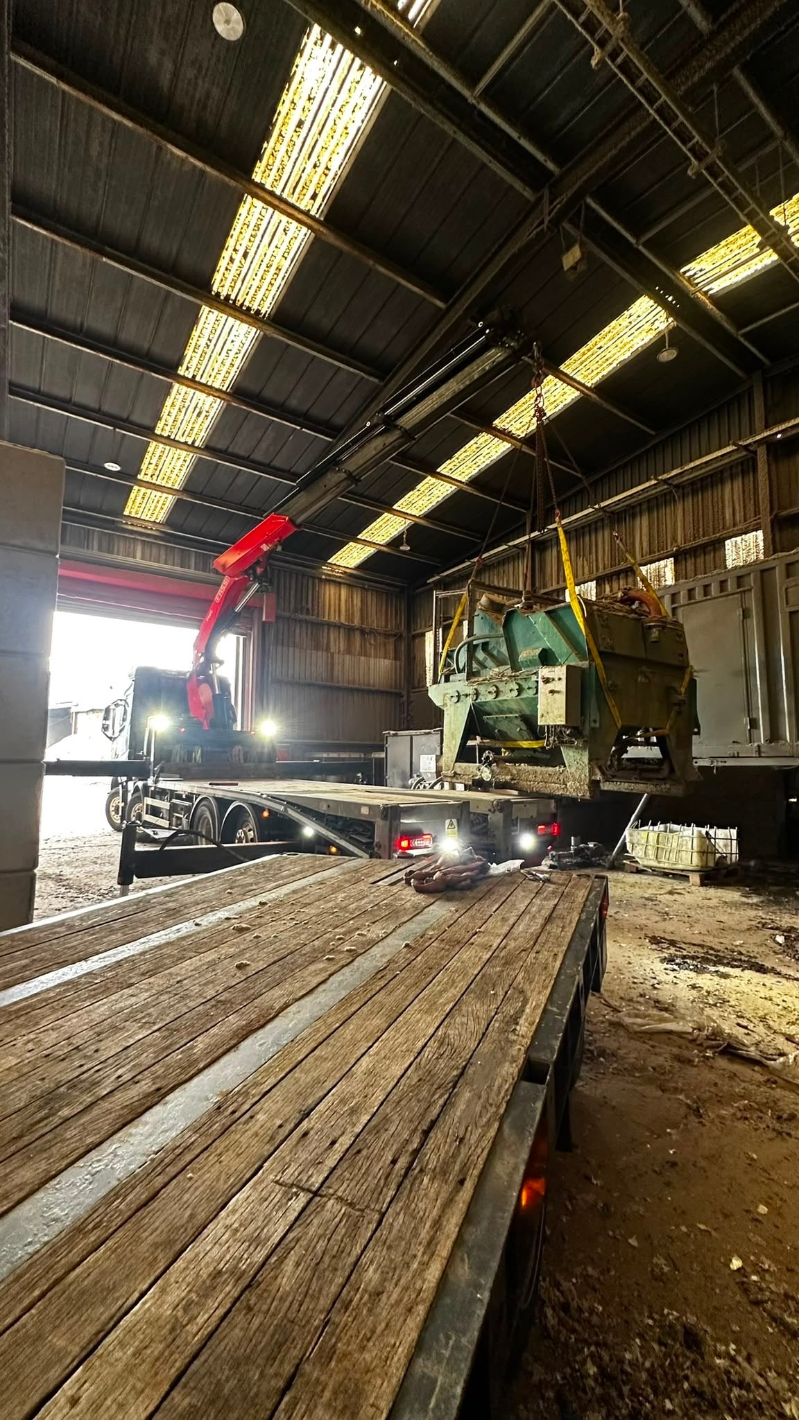 Green industrial machine lifted inside a warehouse